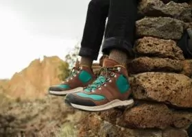 Person wearing Danner Boots sitting on cliff