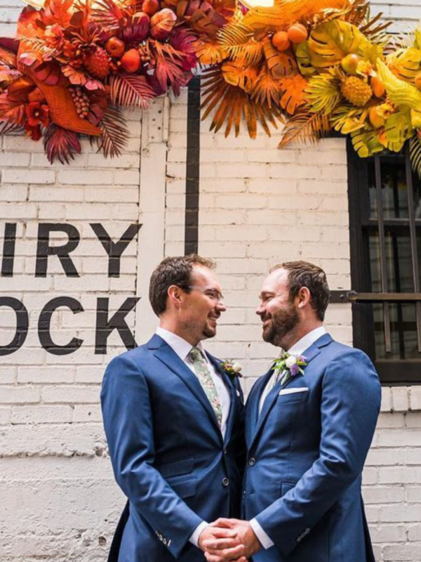 groom and groom taking wedding photos in the alley at dairy block denver