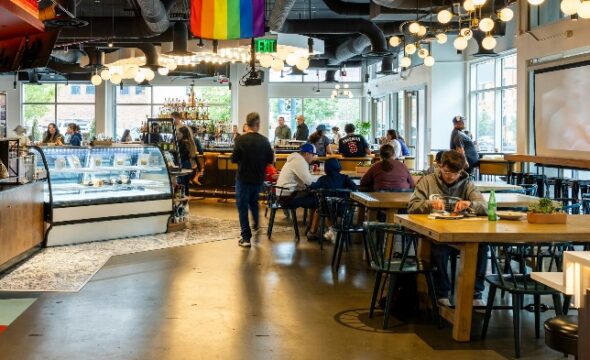People seated and walking in a modern café with bright lighting