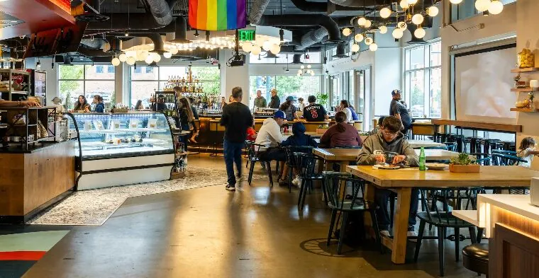 People seated and walking in a modern café with bright lighting