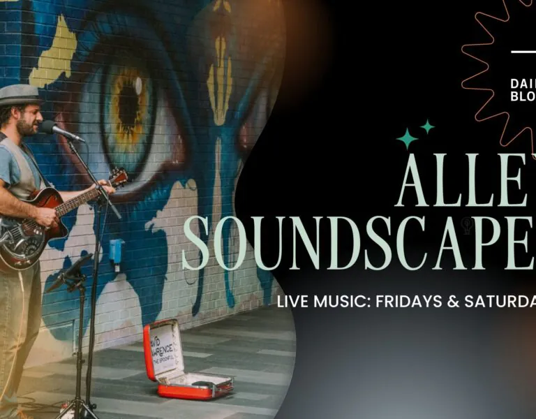 Musician playing guitar near eye mural; 